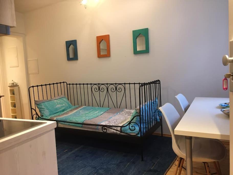 Una cama pequeña en una cocina con una mesa y sillas. en Ferienwohnung in der Innenstadt, en Leutkirch im Allgäu