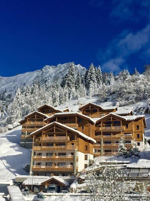 un grand bâtiment dans la neige avec une montagne dans l'établissement Appartement confortable pour 6 personnes, à Champagny-en-Vanoise