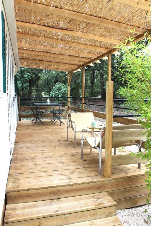 une terrasse en bois avec une pergola en bois dans l'établissement Le Petit Saint Trophime, à Saint-Rémy-de-Provence