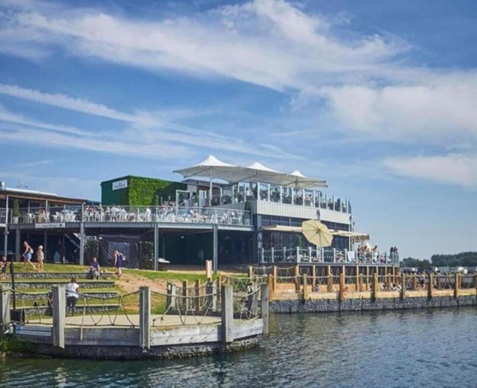a restaurant on the water with people on the dock at A HOME AWAY HOT TUB RETREAT AT Tattershall lakes country park in Tattershall