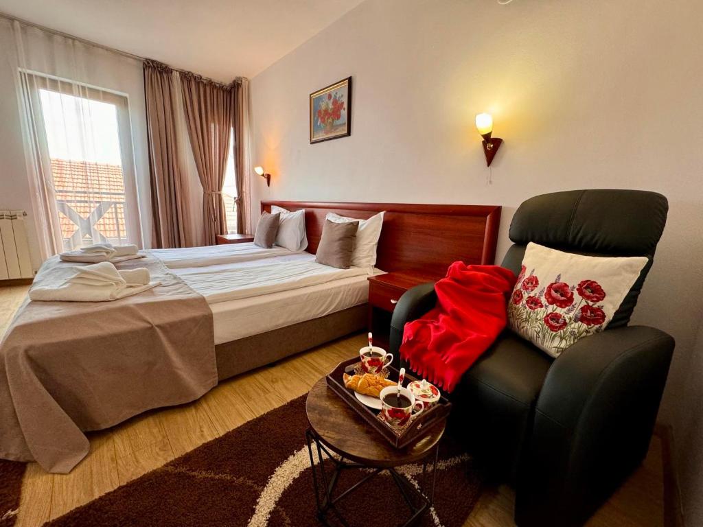 ein Hotelzimmer mit einem Bett und einem Stuhl in der Unterkunft Honey House in Bansko