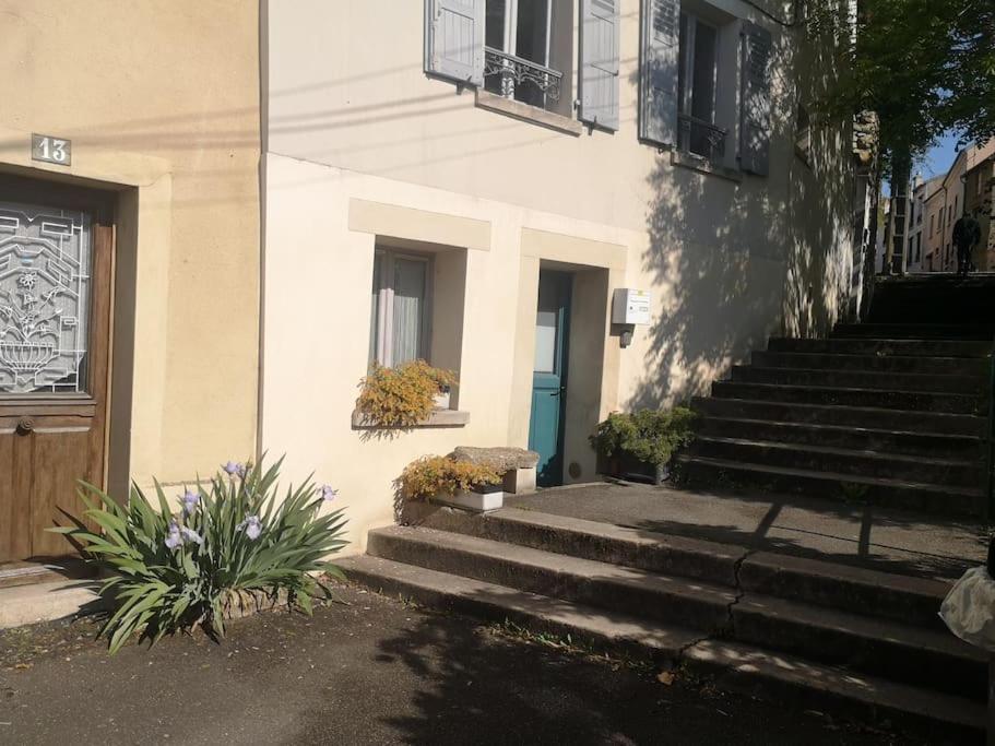 Un edificio con escaleras que conducen a una puerta con una ventana. en Studio atypique, en Conflans-Sainte-Honorine