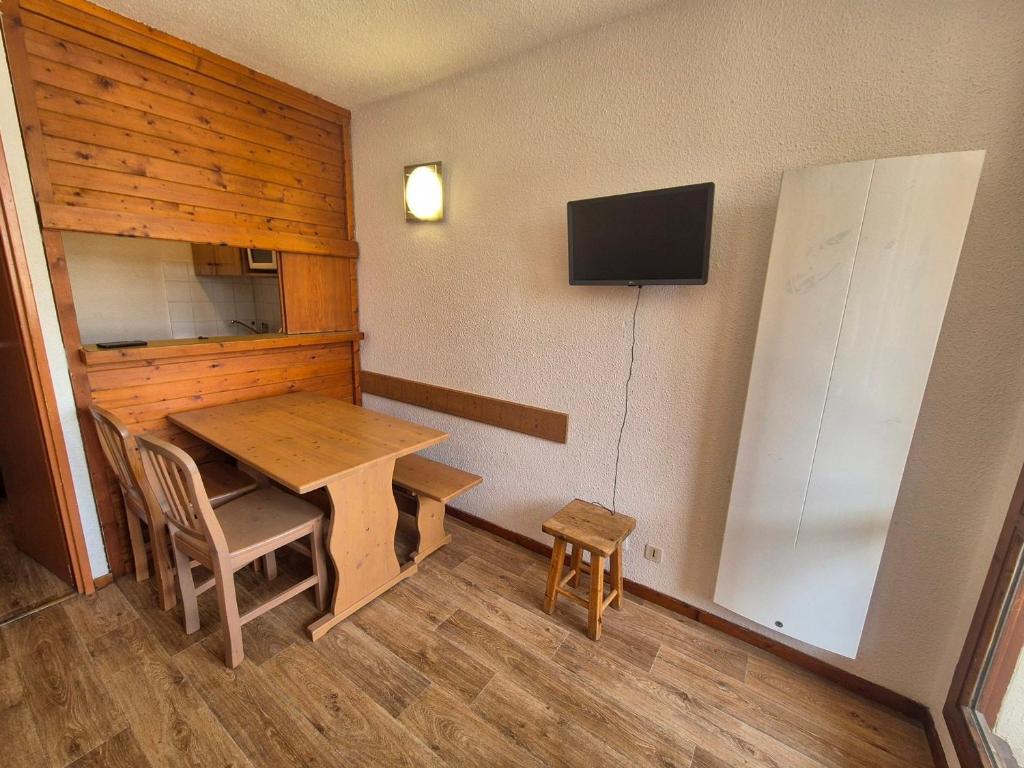 une pièce avec une table et une télévision sur un mur dans l'établissement Studio cosy à Tignes Val Claret - 10m des pistes avec balcon, idéal pour 4 personnes - FR-1-502-429, à Tignes