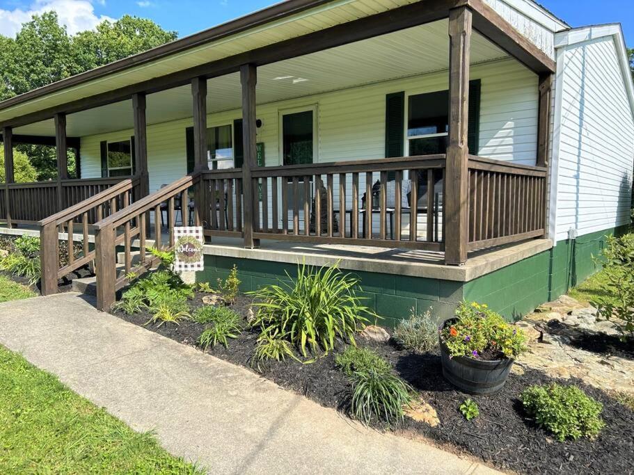a house with a porch with wooden railings and plants at Grassy Meadow Getaway - HOT TUB! in Mount Nebo