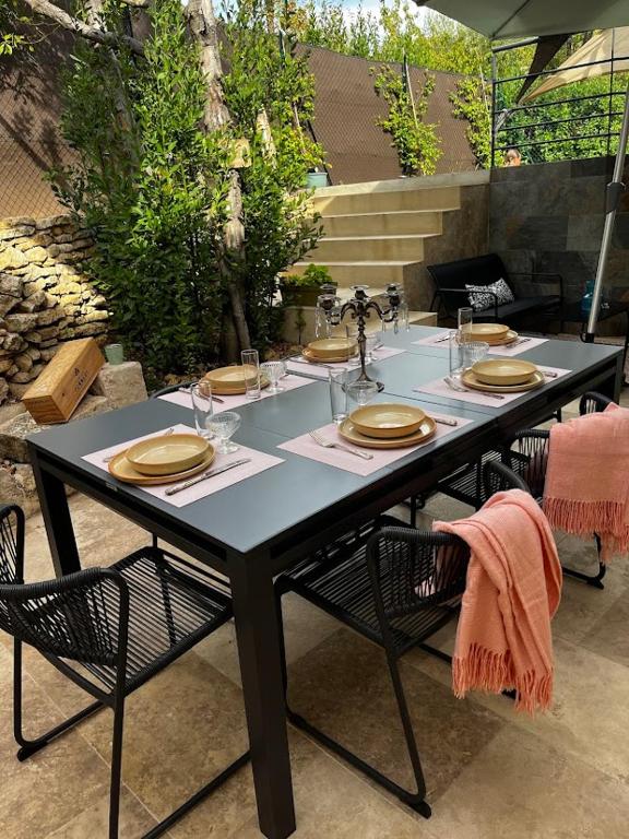 une table noire avec des chaises, des assiettes et des verres dans l'établissement Villa Simone proche Uzes, à Blauzac