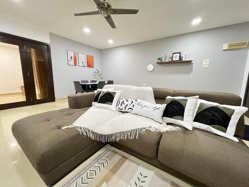 a living room with a couch and a ceiling fan at YOLO4 4BR 16PAX CentralTown Netflix in Kuantan