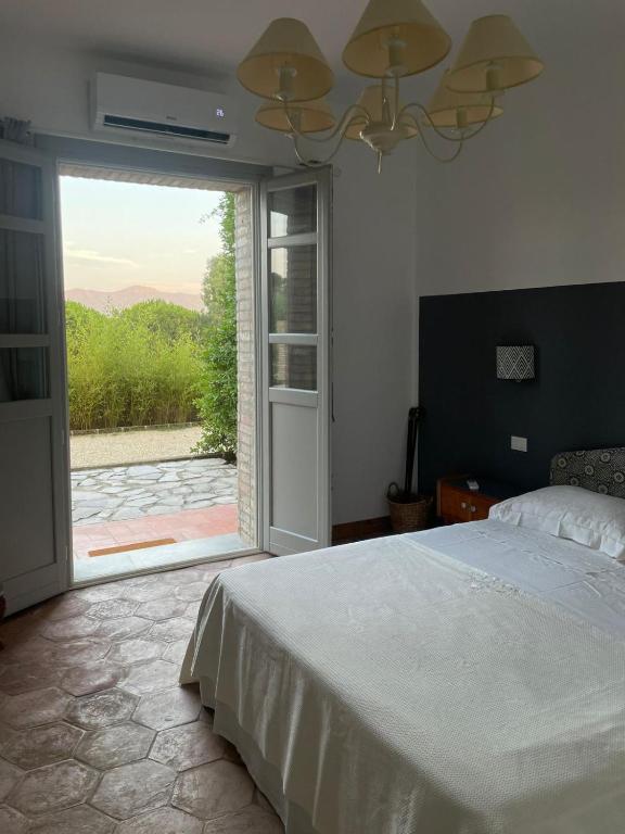 una camera con letto e porta scorrevole in vetro di La Pausa a Portoferraio