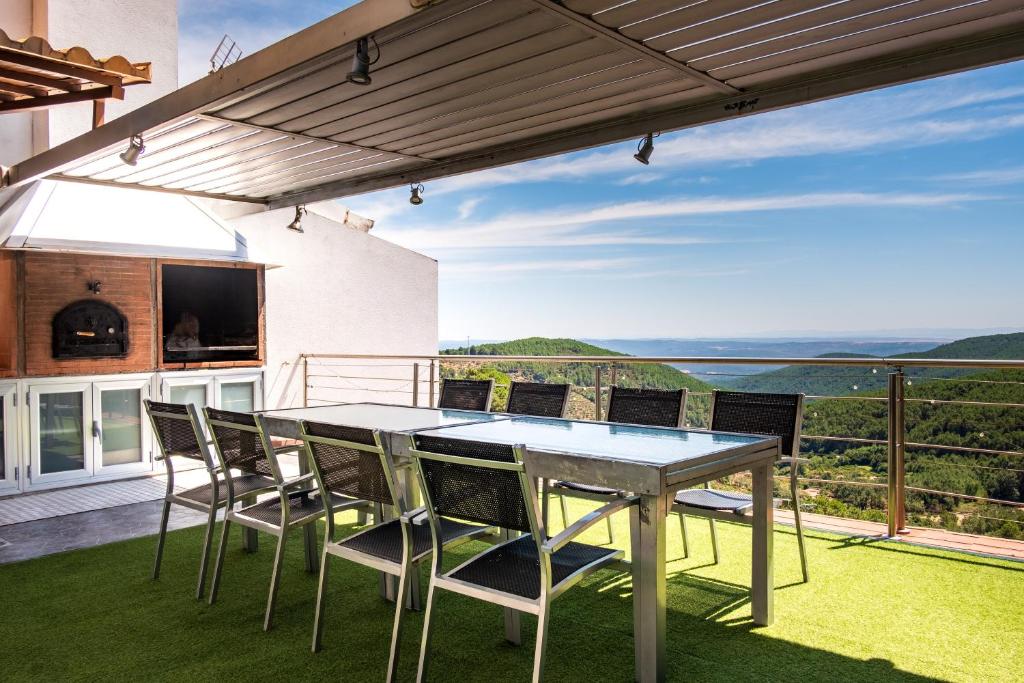 a dining table and chairs on a patio with a view at Entregredos in Guisando