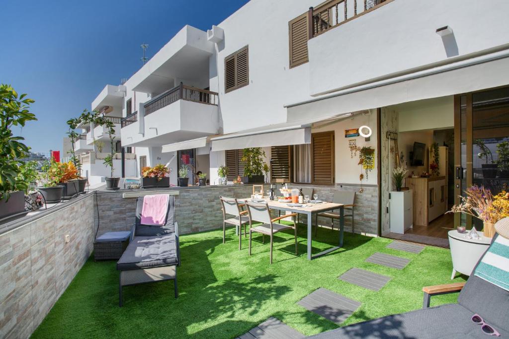 un patio avec une table et des chaises sur l'herbe dans l'établissement Esther Dream Bungalow, à Mogán