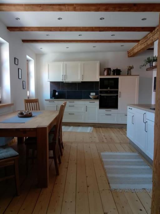 a kitchen with a wooden table and a wooden floor at Ferienwohnung Gisela 80qm in Gernrode - Harz
