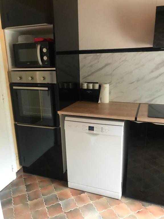 Il comprend une cuisine équipée d'une cuisinière et d'un lave-vaisselle blanc. dans l'établissement Ly Jymjac Saint Hilaire de Riez St Jean de Monts, à Saint-Hilaire-de-Riez