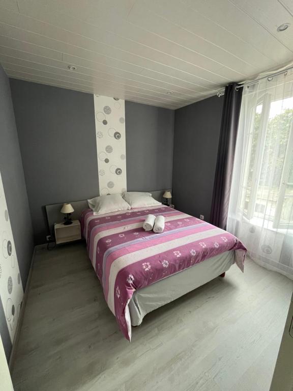 a bedroom with a large bed with a pink blanket at Étape lembronnaise in Saint-Germain-Lembron