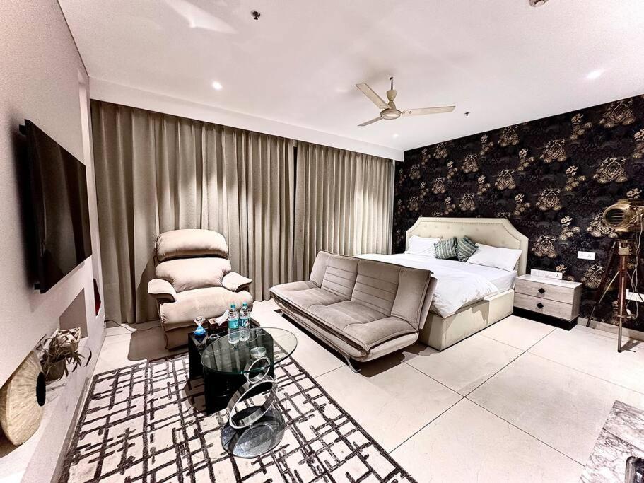 ein Schlafzimmer mit einem Bett und einer Couch in der Unterkunft Luxury Studios Key 3 in Gurgaon