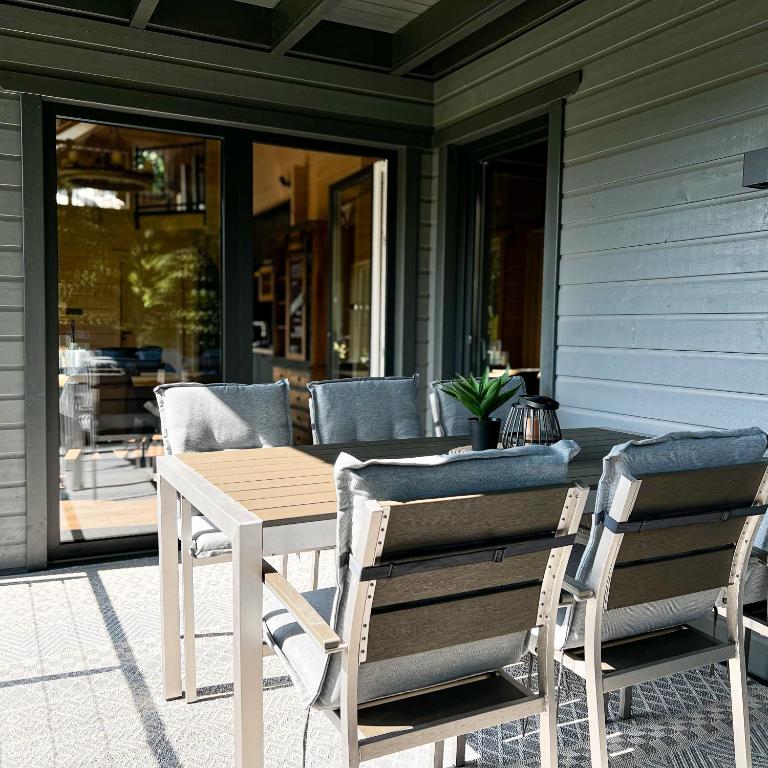 a wooden table and chairs on a porch at Hercynia Lodge in Bad Lauterberg