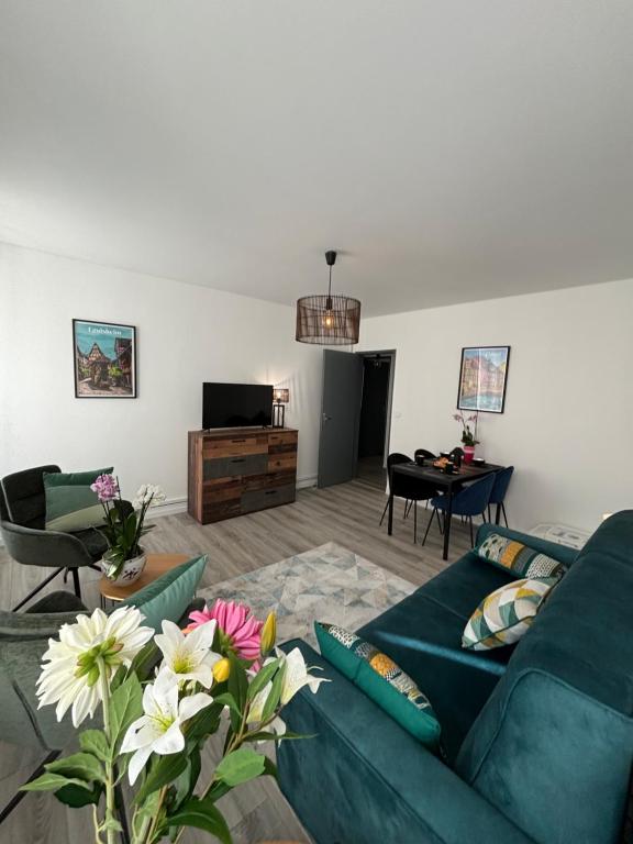 - un salon avec un canapé vert et des fleurs dans l'établissement L Alsacienne F2 centre ville, à Mulhouse