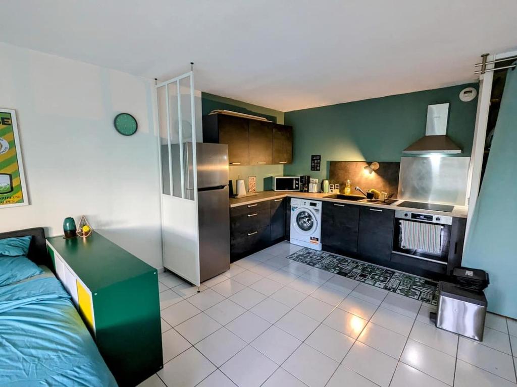 Il comprend une petite cuisine avec des tons verts et blancs. dans l'établissement Grand studio proche de la GARE., à Grenoble