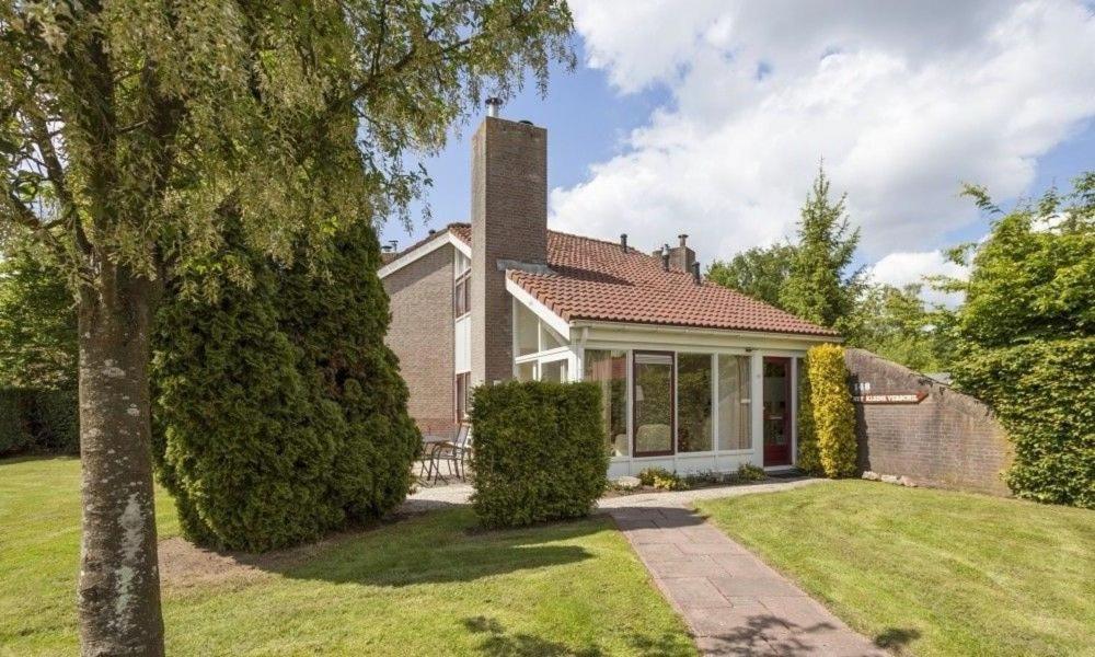 a home with a brick house with a yard at Het Kleine Verschil in Zwiggelte