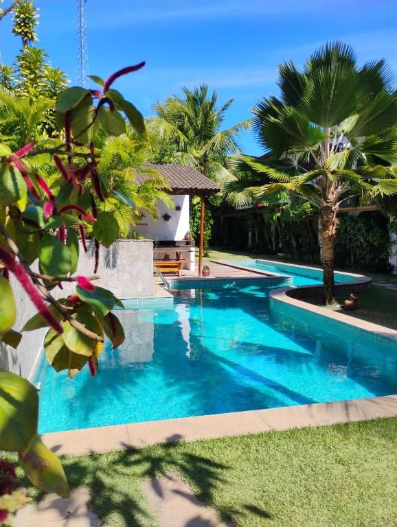 a swimming pool in a yard with palm trees at Flor da Mata in Pipa