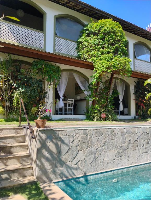 a house with a swimming pool in front of it at Flor da Mata in Pipa