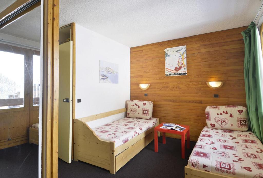 une petite pièce avec un lit et une chaise dans l'établissement Residence 3000 - Studio pour 4 Personnes 16, à Mâcot La Plagne