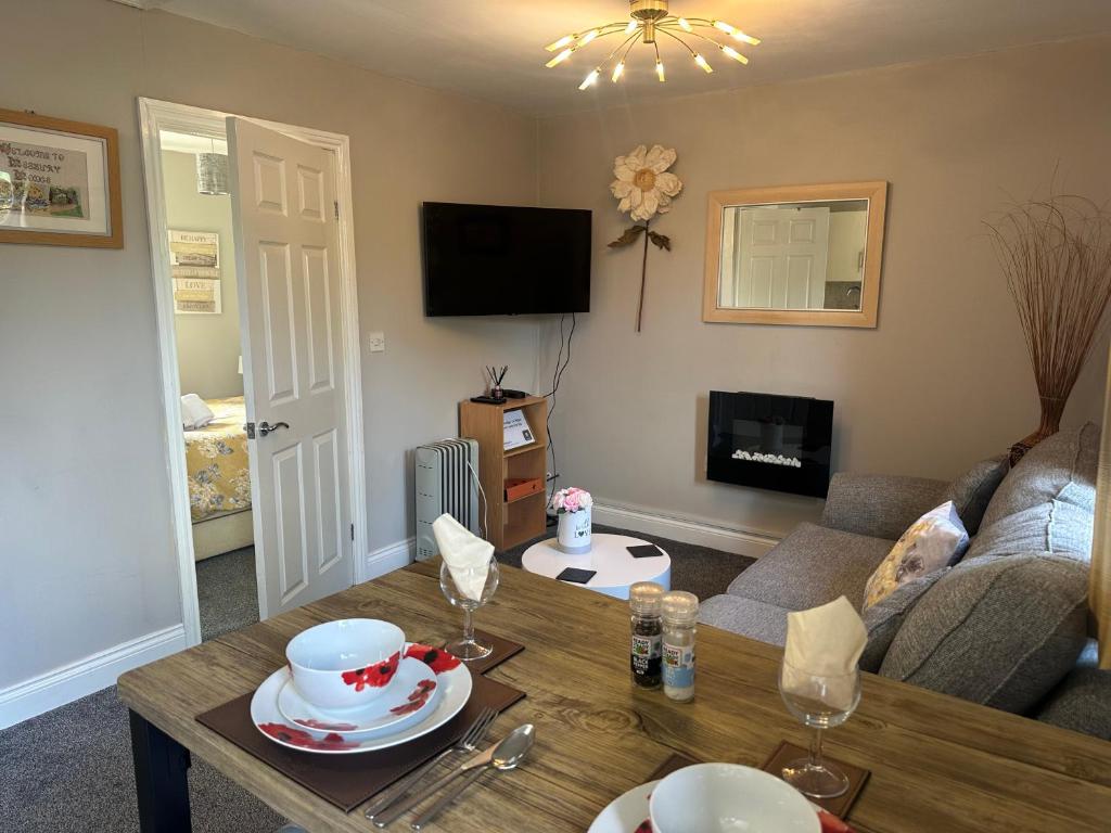 a living room with a couch and a table at Lesbury Lodge - (a 'bijou residence') with hot tub in Alnwick