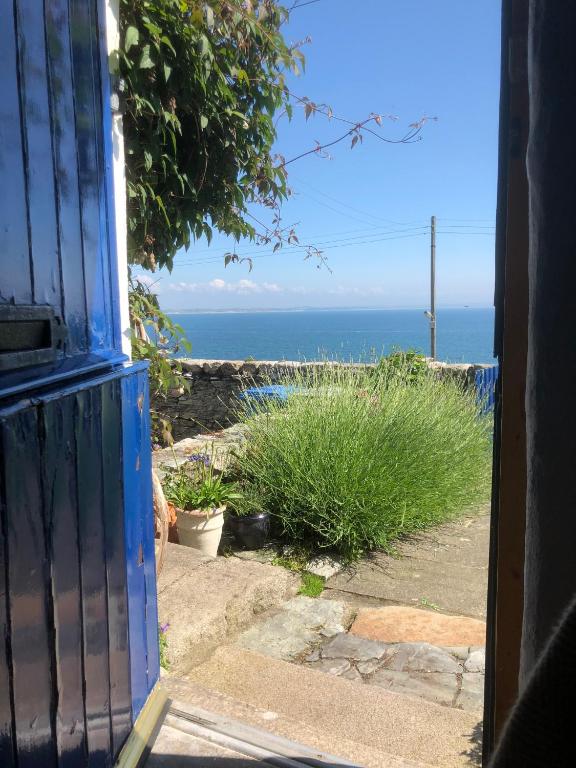 an open door with a view of the ocean at Slieve Donard Cottage Widows Row cottages in Newcastle
