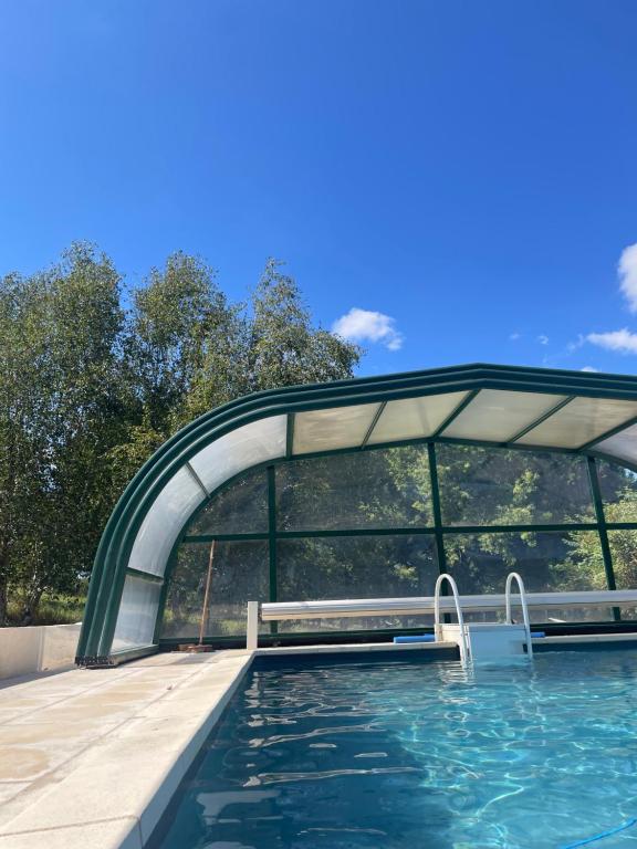 a swimming pool with a bridge over the water at Maison Papillon in Turenne