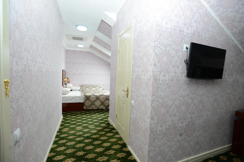 a hallway with a room with a bed and a television at City Line Boutique Hotel in Tashkent