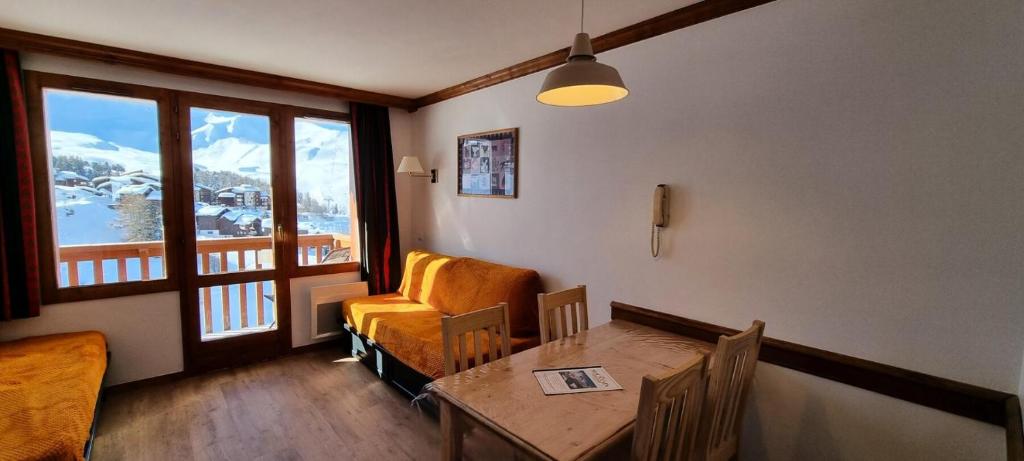 d'une salle à manger avec une table, une chaise et une fenêtre. dans l'établissement Résidence Mont Soleil A - Appartement 5 personnes - Plagne Soleil MAE-0294, à Aime La Plagne