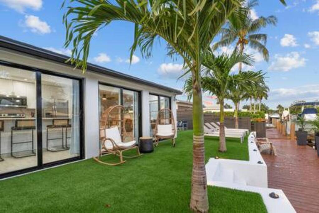 デイニア・ビーチにあるTropical WaterFront Oasisの庭の椅子とヤシの木がある家