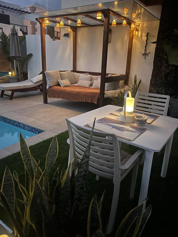 a white table and chair with a candle on a patio at Romantico con piscina privada solo para ti in Punta Mujeres