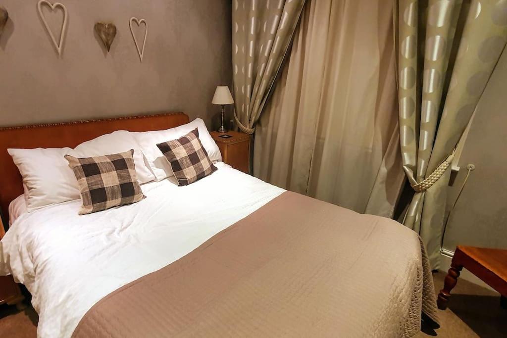 een slaapkamer met een bed met witte lakens en kussens bij Spaside Apartment in Scarborough