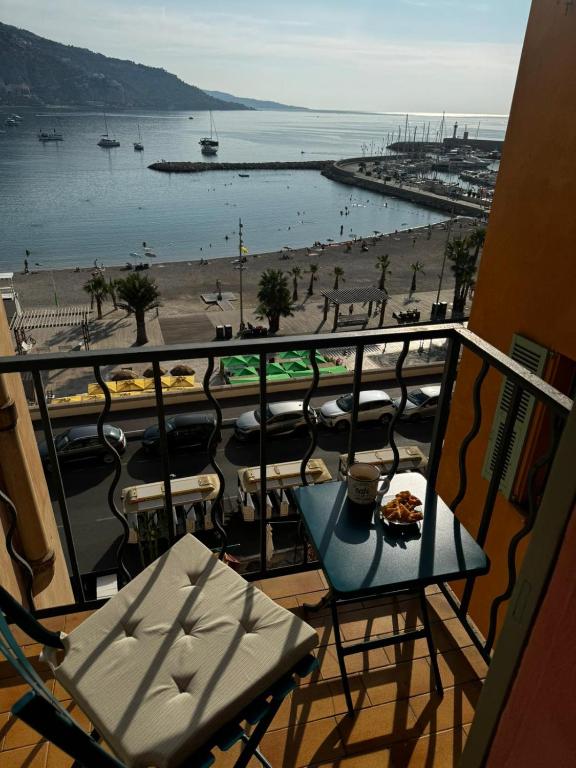 d'un balcon avec une table et une vue sur la plage. dans l'établissement Menton - SABLETTES BEACH VIEW, à Menton