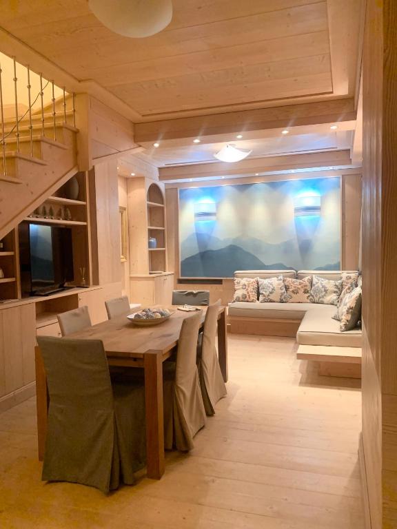 a dining room with a table and a couch at Villa Zubiana in Cortina dʼAmpezzo