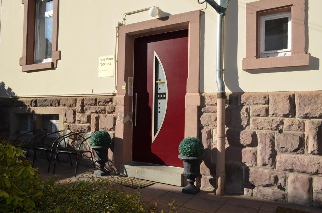 ein Backsteingebäude mit einer Tür mit Stühlen und Pflanzen in der Unterkunft Ferienwohnung Seerose in Baden-Baden