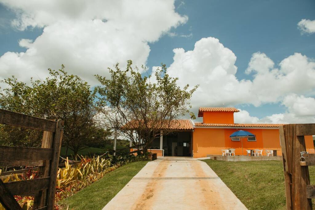 a driveway leading to a house with an orange at Casa de Campo Tamanduá - Conexão com a Natureza! in Piumhi