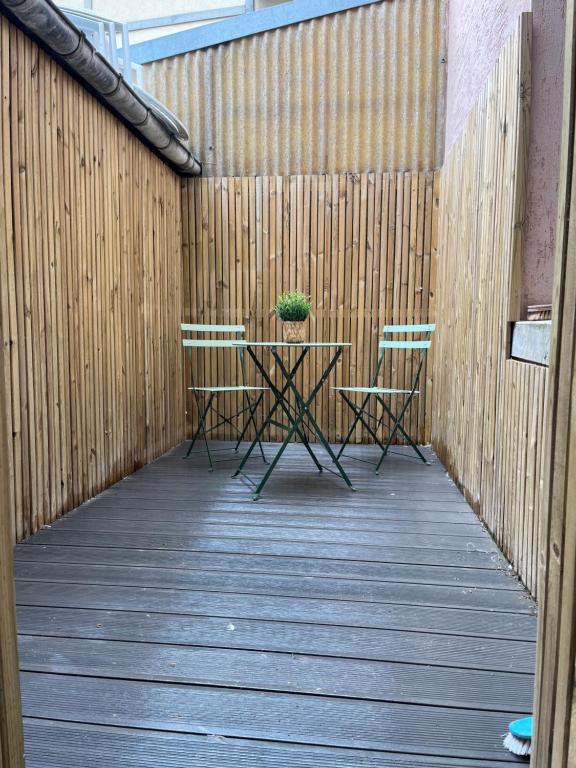 d'une terrasse avec une table et une plante en pot. dans l'établissement La cour secrète, à Deauville