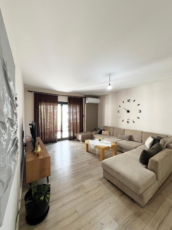 a living room with a couch and a clock on the wall at B2 Apartment in Tirana