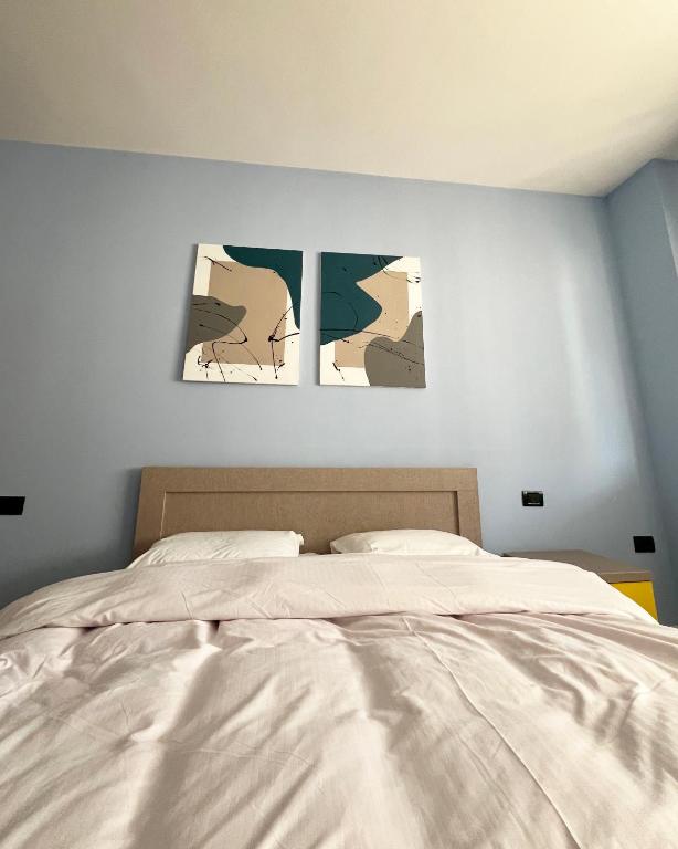 a bedroom with three pictures on the wall at B2 Apartment in Tirana