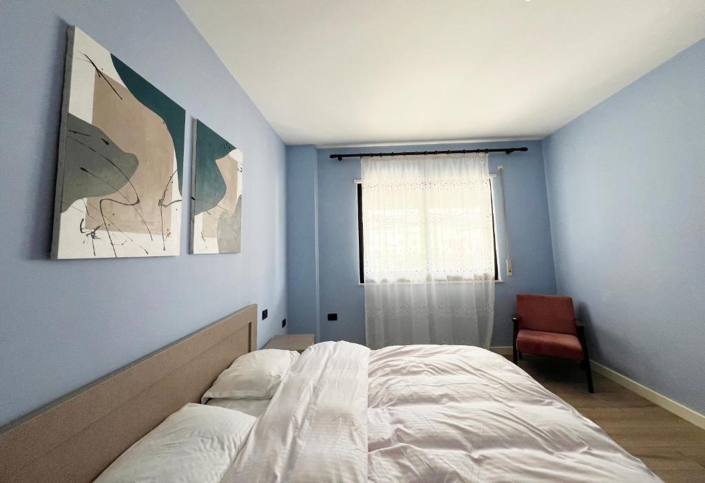 a bedroom with a white bed and a window at B2 Apartment in Tirana