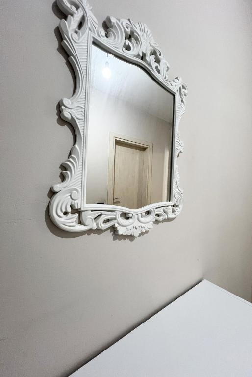 a mirror with a white frame on a wall at B2 Apartment in Tirana