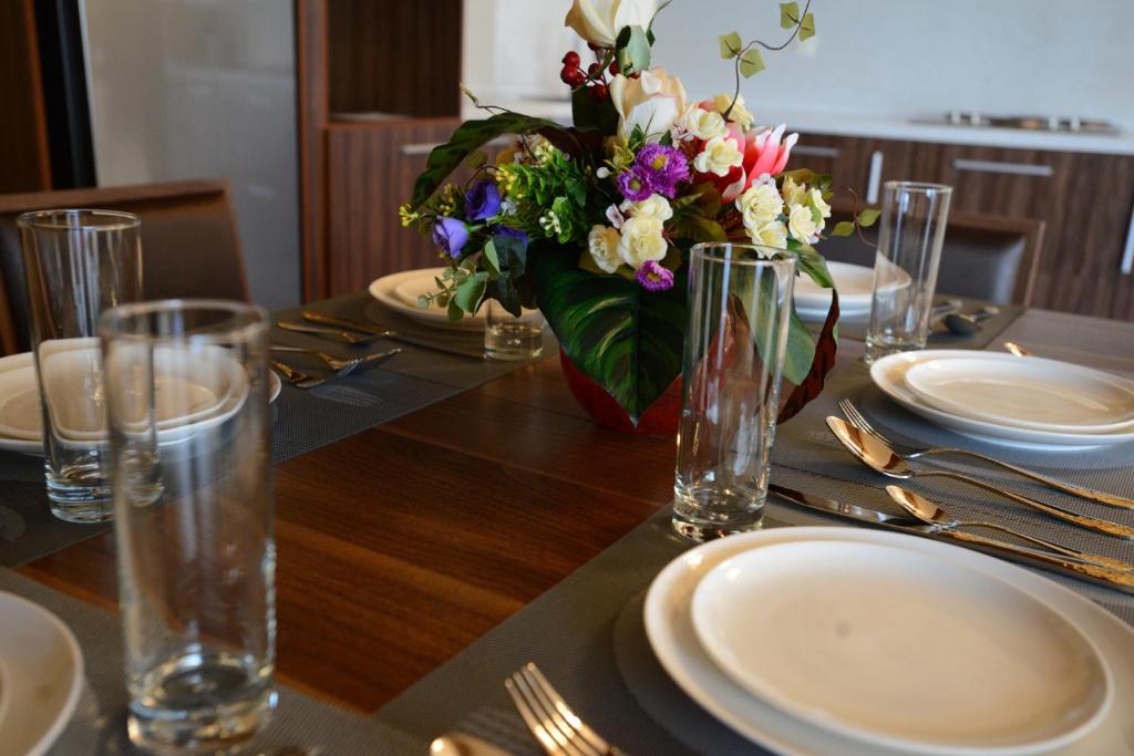 a table with plates and a vase of flowers on it at City Line Boutique Hotel in Tashkent