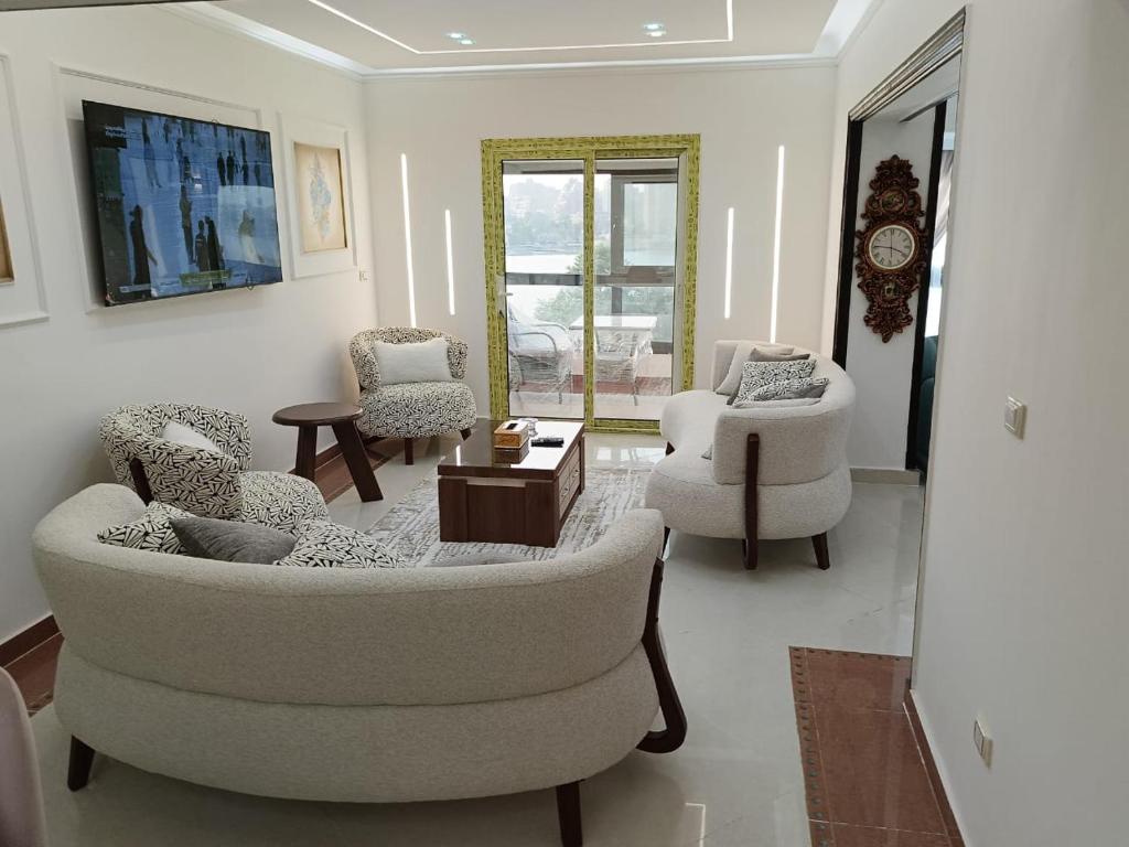 a living room with two chairs and a couch and a table at شقق المنيل in Cairo