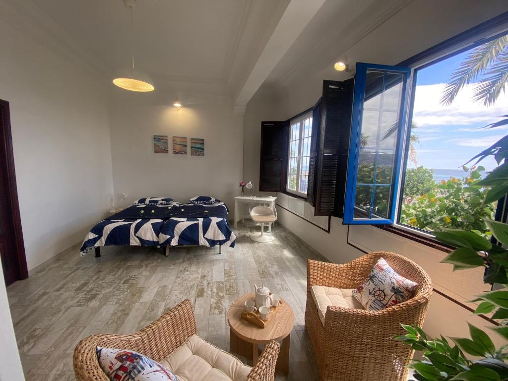 une chambre avec un lit, des chaises et une fenêtre dans l'établissement Apartamento La Pepa - Santa Cruz de La Palma, à Santa Cruz de la Palma