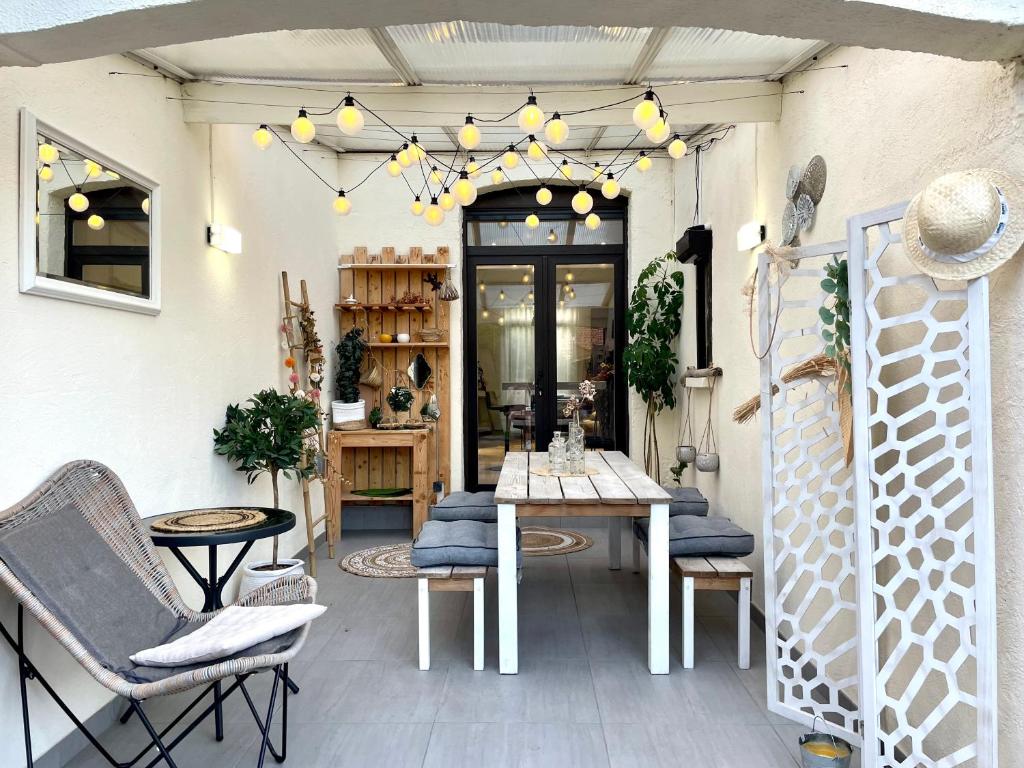 a patio with chairs and a table and a chandelier at Charmante maison à 20min de Lille in Oignies