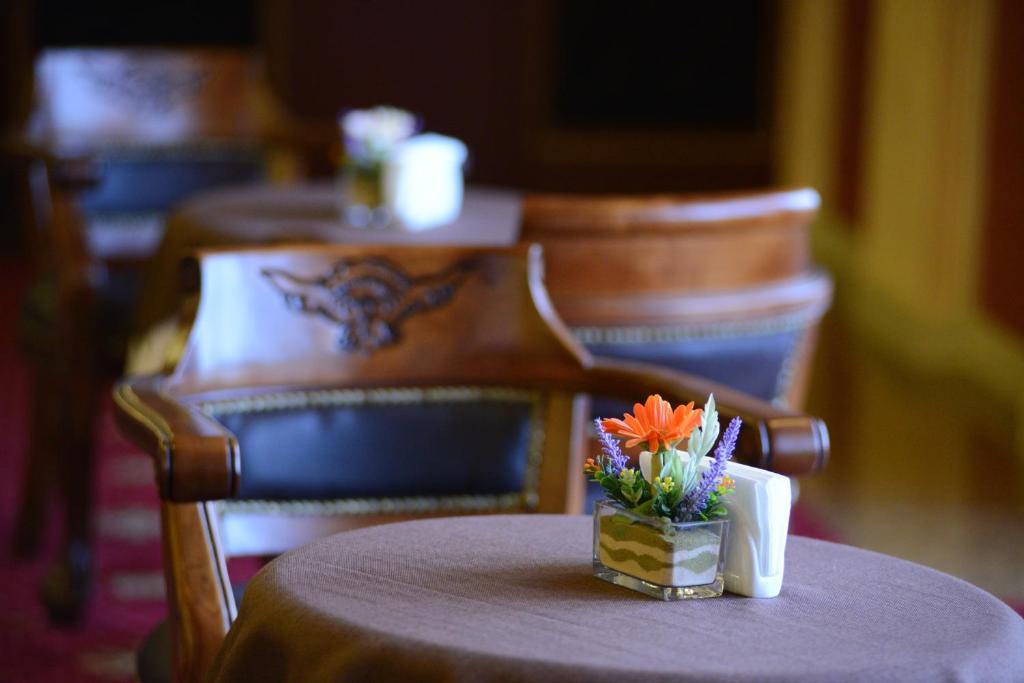 a table with a purple table cloth and a vase with flowers on it at City Line Boutique Hotel in Tashkent