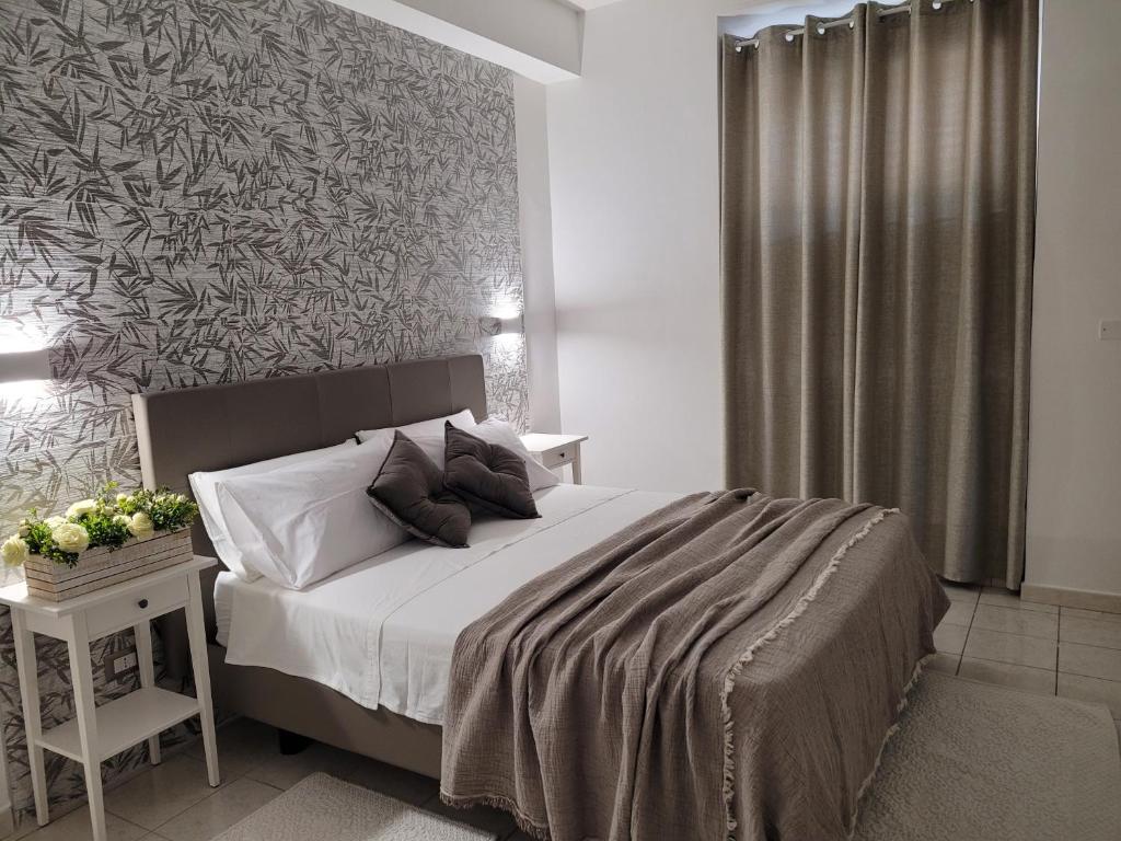 a bedroom with a large bed and a wall at House Torre Galea in Marina di Gioiosa Ionica