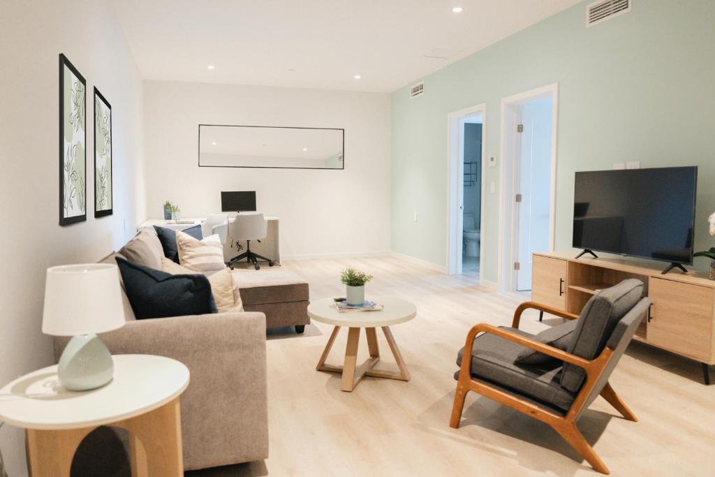 Una sala de estar con un sofá y un televisor. en Governors Village - 1,2,3 &amp; 4 Bedroom Apartments on Seven Mile Beach Corridor, en George Town