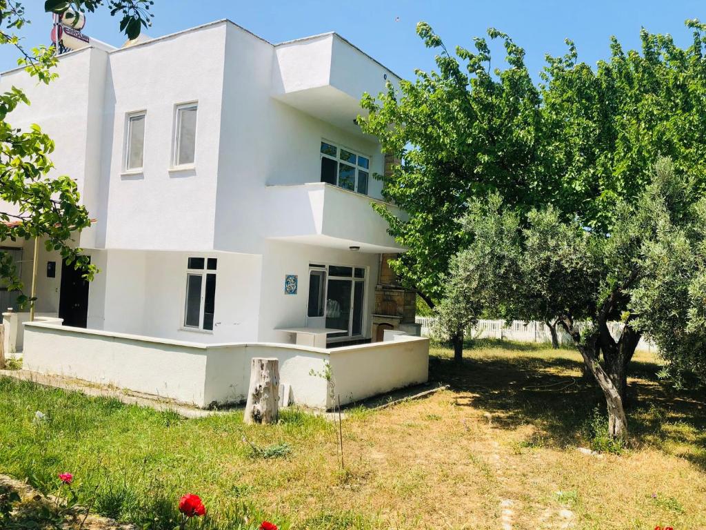 a white house with a tree in front of it at Troya Garden Villa in Canakkale