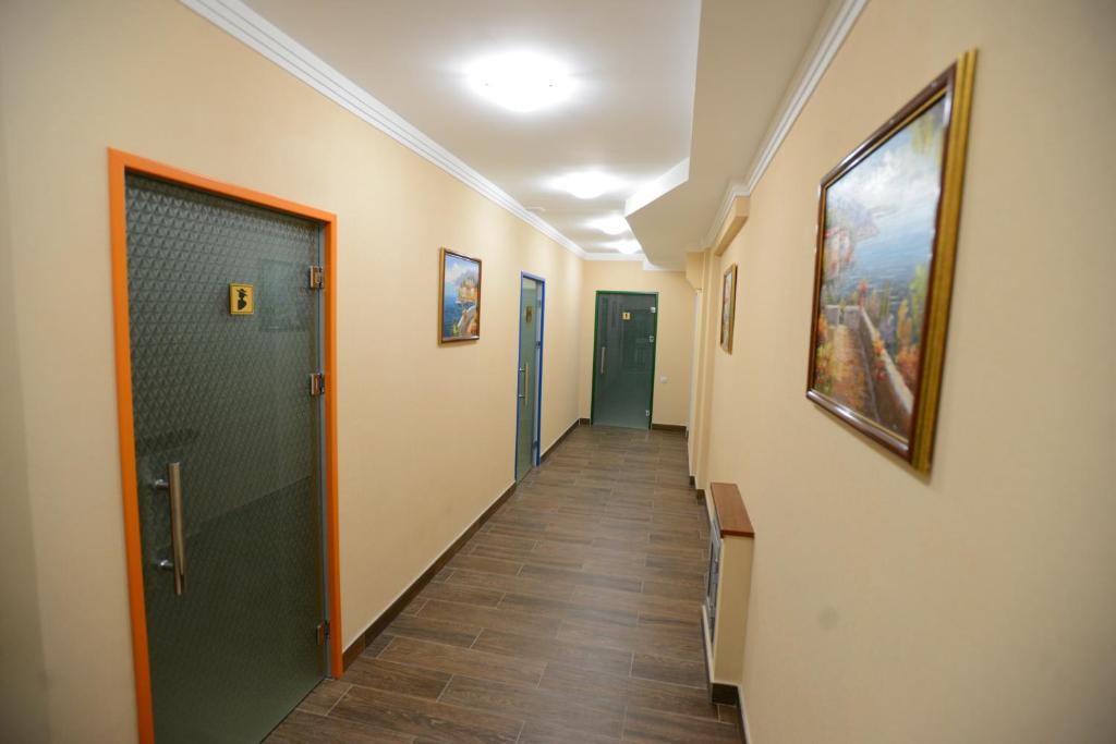 a hallway with a door and paintings on the walls at City Line Boutique Hotel in Tashkent